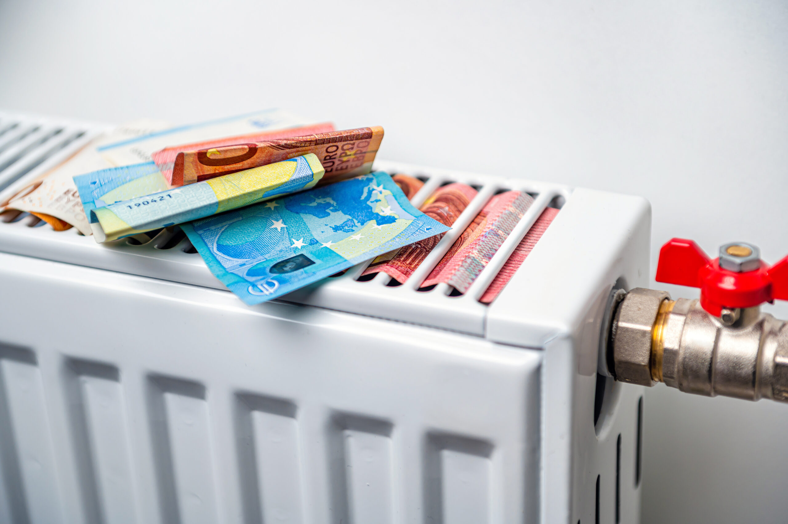 euro banknotes in a central heating radiator, the concept of expensive heating costs, close-up